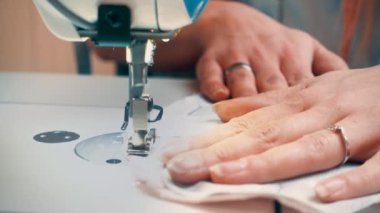 Kadın terzinin atölye masasında otururken makineye dikiş diktiği ekin manzarası