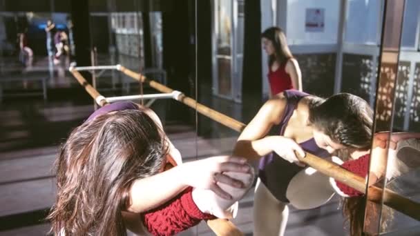 若いダンサーたちがスタジオで一緒にトレーニングし 太陽の光の下で暖かく曲げ — ストック動画