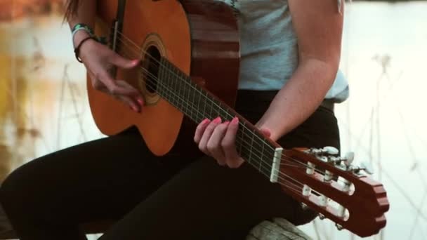 Νεαρή Γυναίκα Παίζει Κιθάρα Κοντά Στο Νερό — Αρχείο Βίντεο