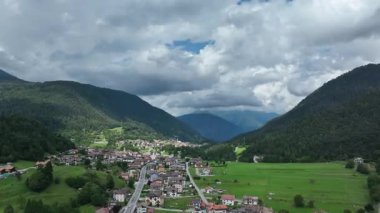 Molveno 'nun havadan görünüşü, İtalya' nın Dolomitler şehrinde yuva yapmış büyüleyici bir köy. Etrafı yemyeşil tepeler ve bulutlu bir gökyüzünün altında dramatik dağlarla çevrili, resim gibi bir manzara sunuyor..