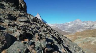 Matterhorn 'un göz kamaştırıcı manzarası berrak mavi gökyüzünün altında engebeli uçurumlar ve sakin dağlık arazi