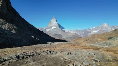 İkonik Matterhorn zirvesi sakin bir alp gölünde güzel bir şekilde yansıyor. Engebeli arazi ve berrak gökyüzü ile çevrili bu sakin manzara İsviçre 'nin doğal güzelliklerini yansıtıyor..