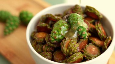 Taze çam kozalaklarının üzerine serpiştirilen bal, doğal dokusunu ön plana çıkarıyor. Bu video organik orman ürünlerinin ve doğal tatlandırıcıların özünü yakalıyor..