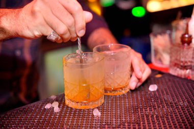 Barmen bir gece kulübünde barın paspasında kokteyl karıştırıyor.