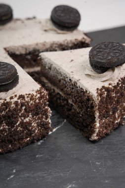 Kurabiye, krema ve kurabiye kaplı çikolatalı pasta dilimleri.