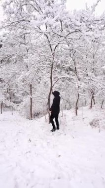 Donmuş ağaçlar ve derin karlarla çevrili, karla kaplı bir yerde duran bir adam. Sakin kış sahnesi, soğuk mevsimin ve huzurlu doğanın özünü yakalar..