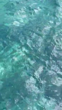 Berrak turkuaz suların büyüleyici görüntüsü, güneş ışığının oyununun görüntüsü yüzeyde karmaşık desenler yaratıyor. Kristal berraklığı su altındaki güzelliği ortaya çıkarıyor..