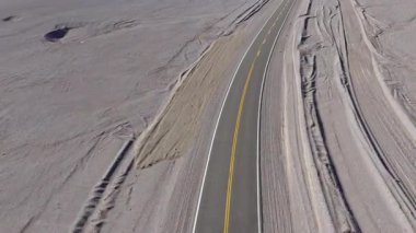 Arjantin, La Puna 'nın engin çöl manzarasını kesen uzak bir yolun havadan görünüşü engebeli araziyi ve bu yüksek rakımlı bölgenin katıksız güzelliğini gözler önüne seriyor..