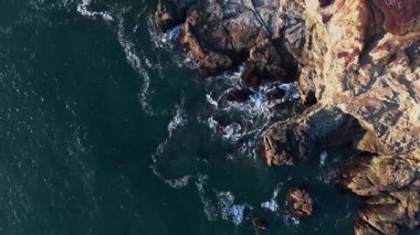 Kaliforniya 'nın engebeli kıyı şeridinin hava manzarası günbatımında dramatik uçurumları ve okyanus ve gökyüzünün canlı renklerini vurguluyor. Seyahat ve doğa meraklıları için mükemmel..