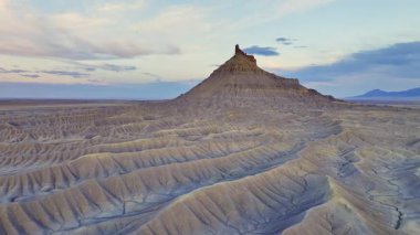 Utah, ABD 'nin engebeli çöllerinde yer alan Butte fabrikası, alacakaranlıkta pastel bir gökyüzüne karşı duruyor ve çorak arazinin eşsiz oluşumlarını gözler önüne seriyor..