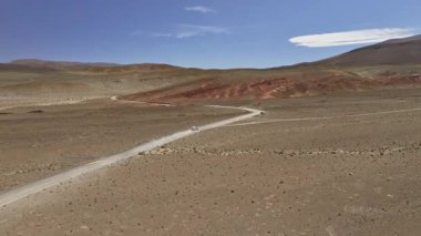 Arjantin 'deki La Puna' nın engin ve yüksek rakımlı arazisinden geçen ıssız bir çöl yolu. Çorak arazinin görkemli manzarası ve berrak gökyüzünün altındaki engebeli tepeler..