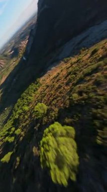 Bir FPV dronu olarak İsviçre Alpleri 'nin çarpıcı bir hava görüntüsü açık mavi gökyüzü altında geniş arazileri, yemyeşil bitkileri ve engebeli dağları yakalar..