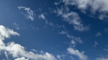 Göz kamaştırıcı bir görüntü pofuduk, beyaz bulutlar canlı, berrak bir mavi gökyüzüne yayılmış, huzur, sükunet ve doğanın genişliğini çağrıştırıyor..