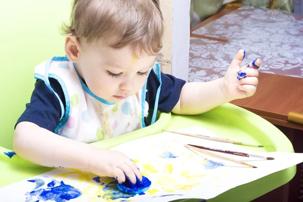 Neşeli çocuk boyalı yüzü ve elleri ile