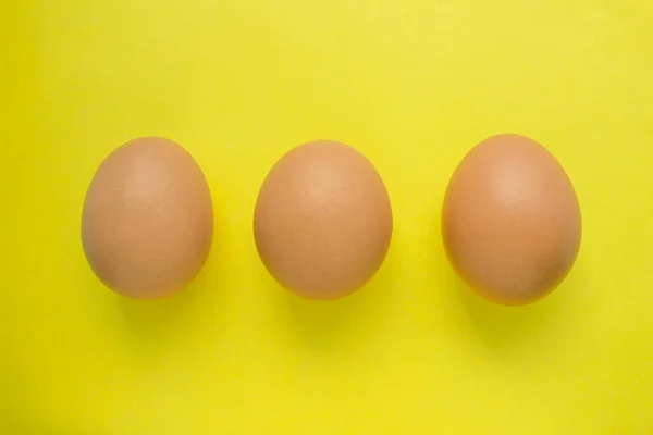 Tres Huevos Pollo Sobre Fondo Amarillo —  Fotos de Stock