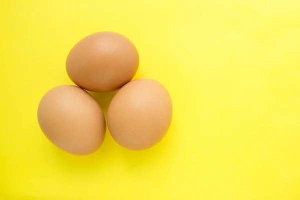 Tres Huevos Pollo Sobre Fondo Amarillo —  Fotos de Stock