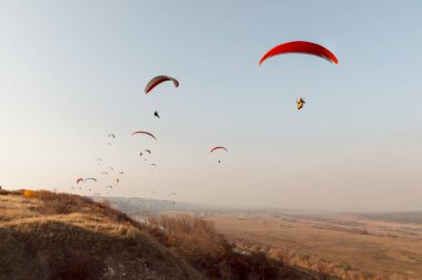 Paragliderler sonbaharda tepelerin üzerinden uçar.