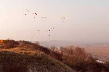 Paragliderler sonbaharda dağların ve nehirlerin üzerinden uçar.