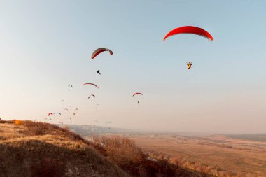 Paragliderler tepelerin üzerinden uçar