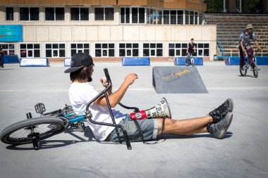 Kaykaycılar Almaty, Kazakistan 'daki bir kaykay parkında numara yapıyor.