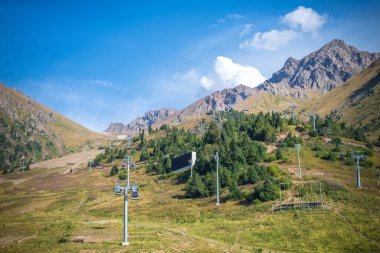 Dağları ve teleferiği olan güzel bir manzara.