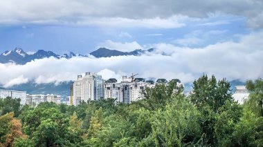 Dağların arka planında gökdelenlerin görüntüsü