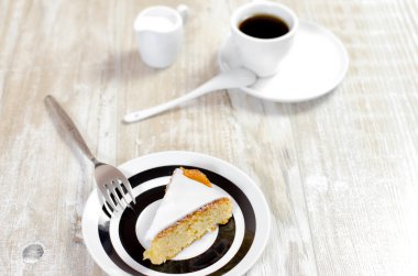 Lemon pie with creamy sauce on a white plate on a wooden rustic table, selective focus and retro style