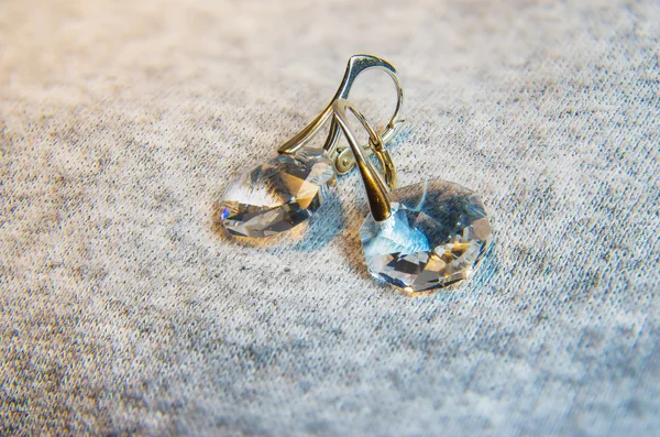 Pair of blue crystal earrings on colorful background