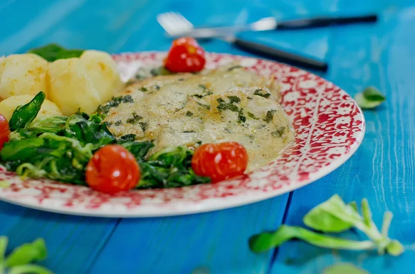 Closeup of Roast turkey with potatoes and rucola, tomatoes on blue wooden table