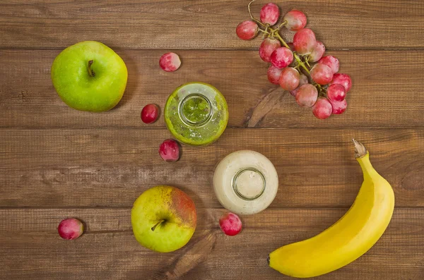 Fresh homemade smoothie with kiwi, bananas, grapes, apple on wooden table