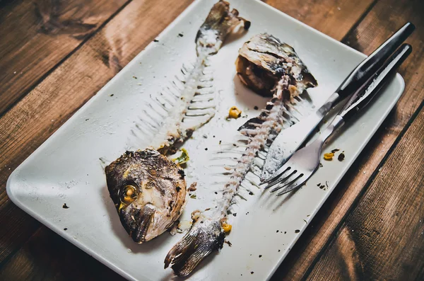 Fishbone of dorada fish on wooden brown table — Stock Photo, Image