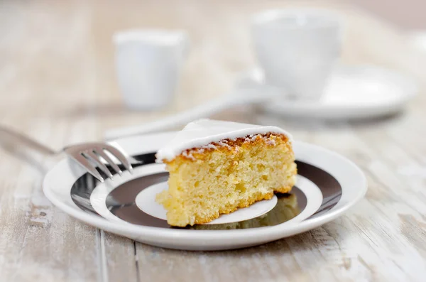 Lemon pie with creamy sauce on a white plate on a wooden rustic table, selective focus and retro style