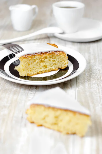 Lemon pie with creamy sauce on a white plate on a wooden rustic table, selective focus and retro style