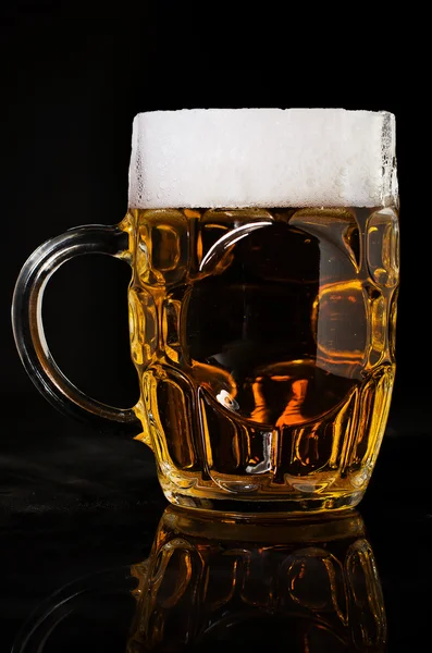 Closeup of pint of beer on black background. Isolated beer