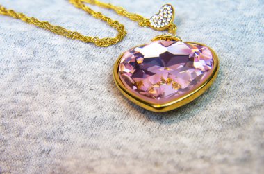 Golden necklace with pink heart on chain. Valentine's day gift