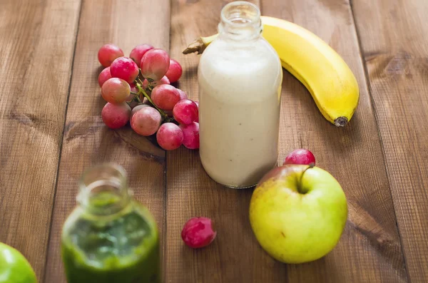 Fresh homemade smoothie with kiwi, bananas, grapes, apple on wooden table