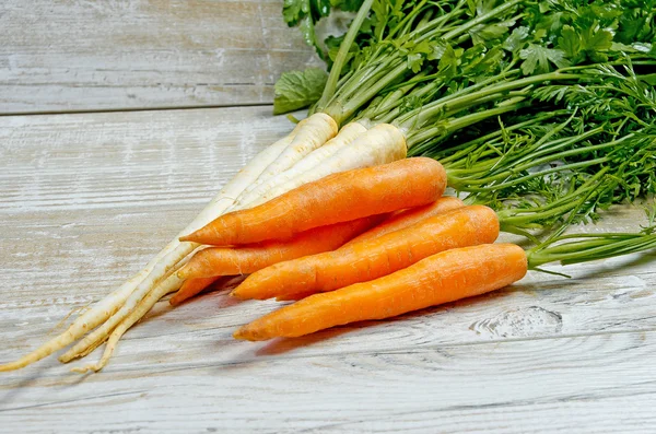 Verduras jóvenes de primavera sobre fondo de madera. Las zanahorias, el perejil - la cosecha fresca del jardín — Foto de Stock