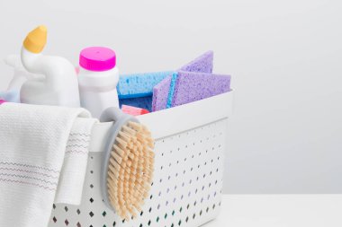 Beyaz arka planda kovadaki birçok temizlik ürünü