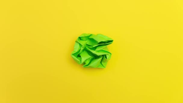 Stop Motion Animation Green Paper Ball Unwrapping Yellow Background Tela — Vídeo de Stock