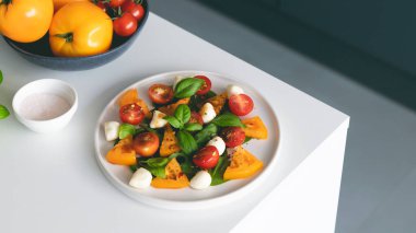 Domatesli İtalyan caprese salatası, mozzarella peyniri ve tabakta fesleğen. Yüksek kalite fotoğraf