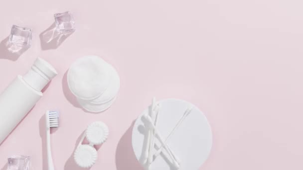 耳スティック 綿パッド トナー ローション アイスキューブ ピンクの背景に歯ブラシ 美と衛生の概念 — ストック動画