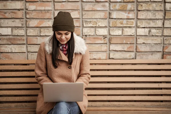 Happy Brunette Freelancer Beanie Hat Using Laptop While Sitting Bench — Stock Photo, Image