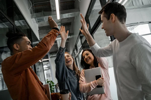 Happy Interracial Students Holding Gadgets Giving High Five — Stock Photo, Image