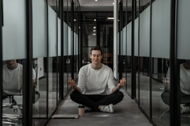Gözleri kapalı bir öğrenci koridorda meditasyon yapıyor.