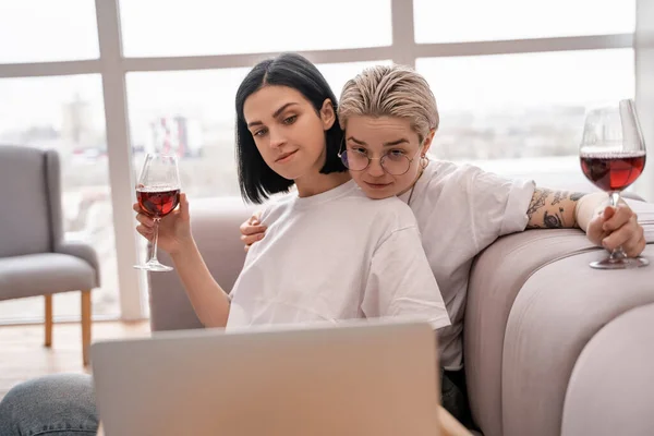 Pareja Lesbiana Viendo Película Ordenador Portátil Mientras Sostiene Vasos Vino — Foto de Stock