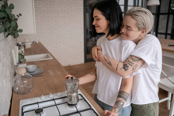 Joven Mujer Gafas Abrazando Feliz Novia Cerca Cafetera Estufa — Foto de Stock