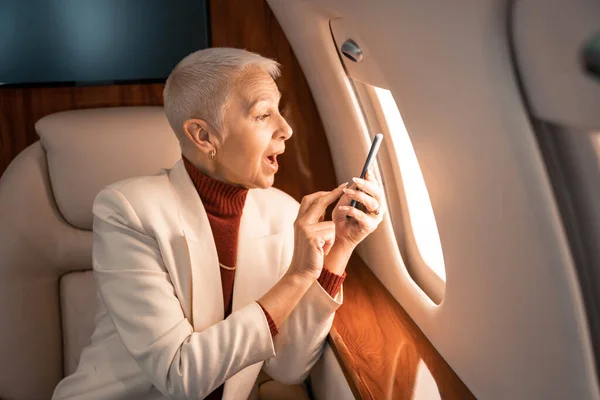 Amazed Businesswoman Smartphone Looking Window Private Plane — Stock Photo, Image