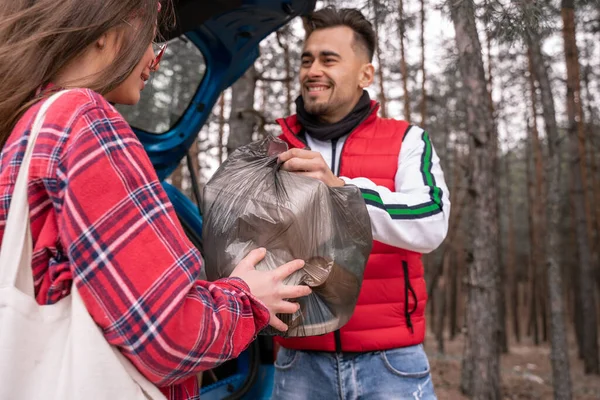 Mujer Joven Gafas Sol Hombre Feliz Sosteniendo Bolsa Basura Bosque — Foto de Stock