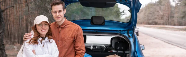 Happy Man Hugging Woman Glasses Cap Car Woods Banner — Stock Photo, Image