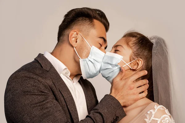 Young Newlyweds Protective Masks Kissing Isolated Grey Lilac Shade —  Fotos de Stock